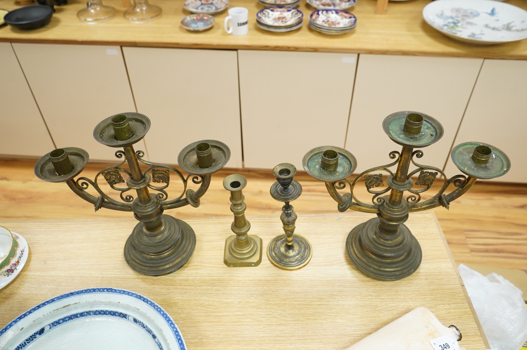 A pair of two brass branch, three light candelabra and two other brass candlesticks, largest 38cm high